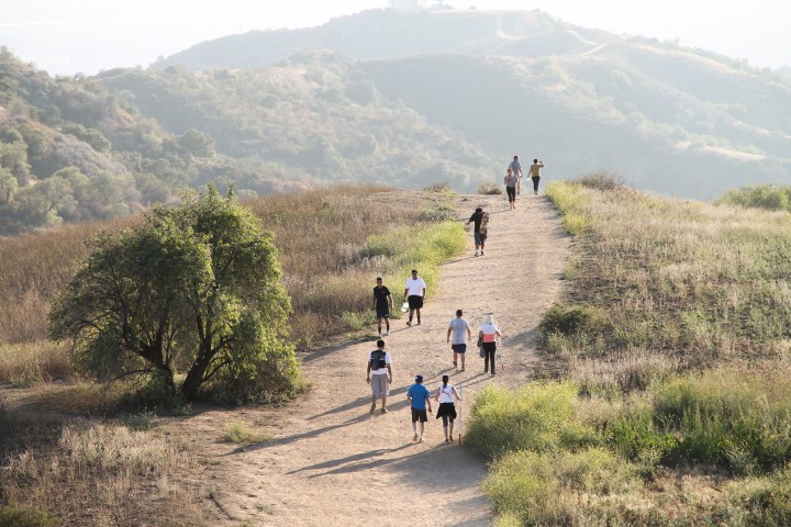 People walking dry dirt trail hill 720x480